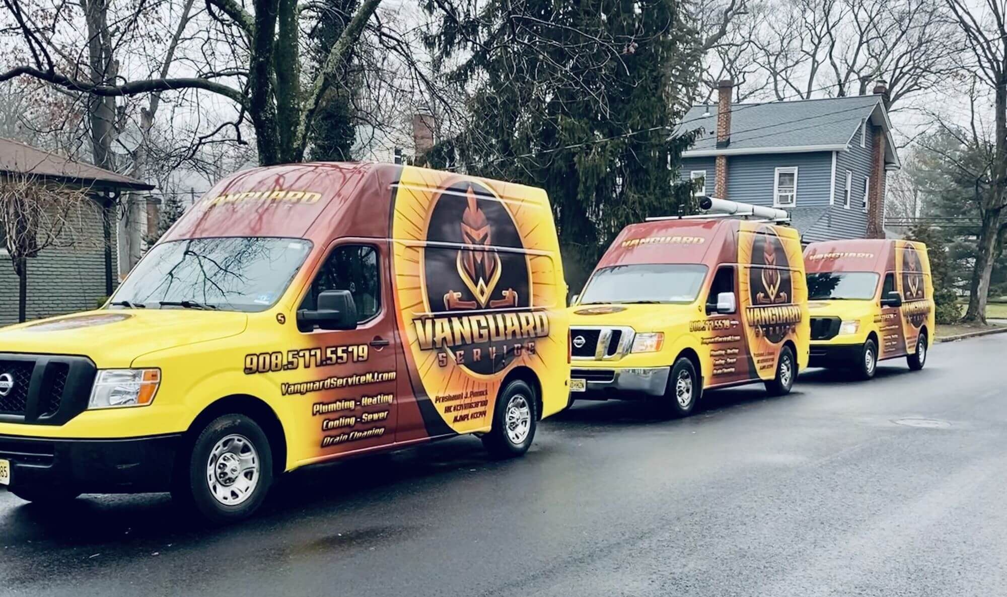 Three Vanguard Service NJ vans parked along a residential street