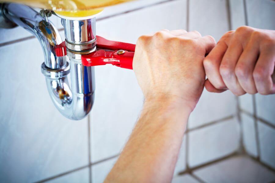 Plumber-working-under-the-sink-image